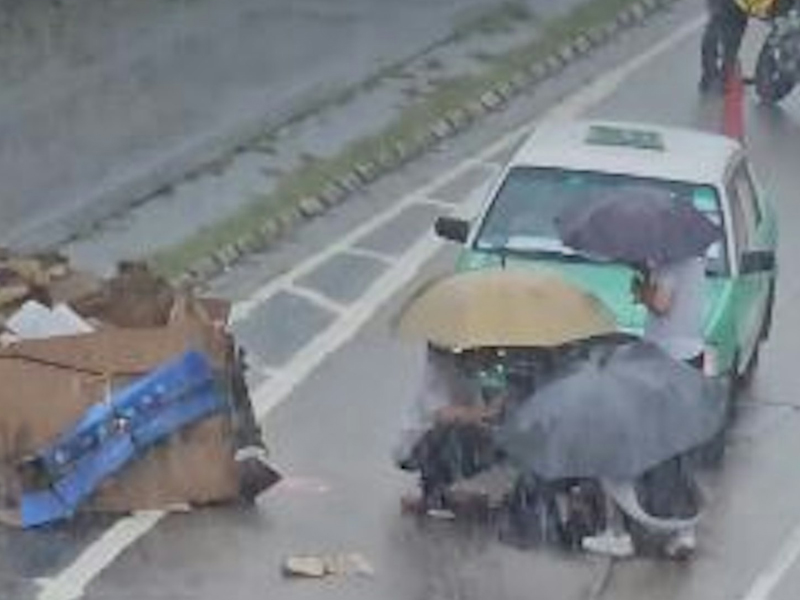 滂沱大雨中，女子推紙皮車捱的士撞飛，好心人撐傘擋雨